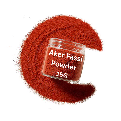 Jar of Aker Fassi Powder with red powder spilled around on a white background