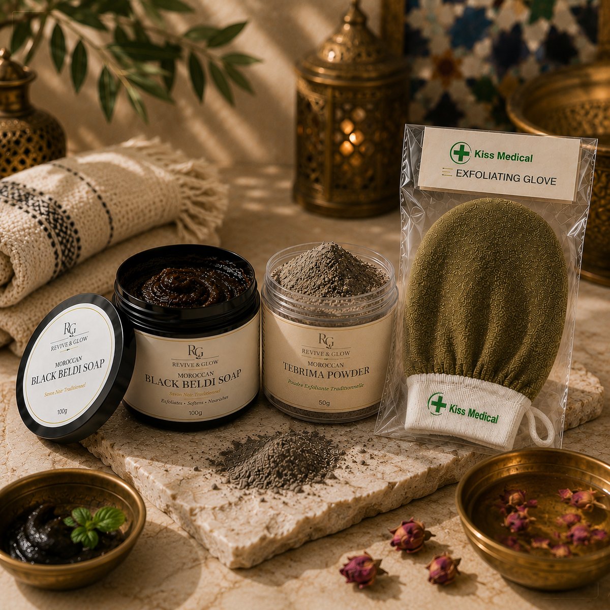 A styled flat-lay of skincare products on a stone slab: a jar of black seed soap, a jar of therma powder, a packaged exfoliating glove from Kiss Medical, and small bowls with rose petals and herbs, set against a warm decorative background.