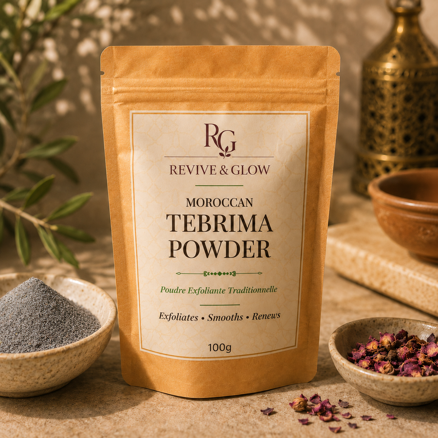 A stand-up pouch of Revive & Glow Moroccan Tebrima Powder stands on a stone surface, surrounded by bowls of loose powder and dried rose petals, with a softly styled background.