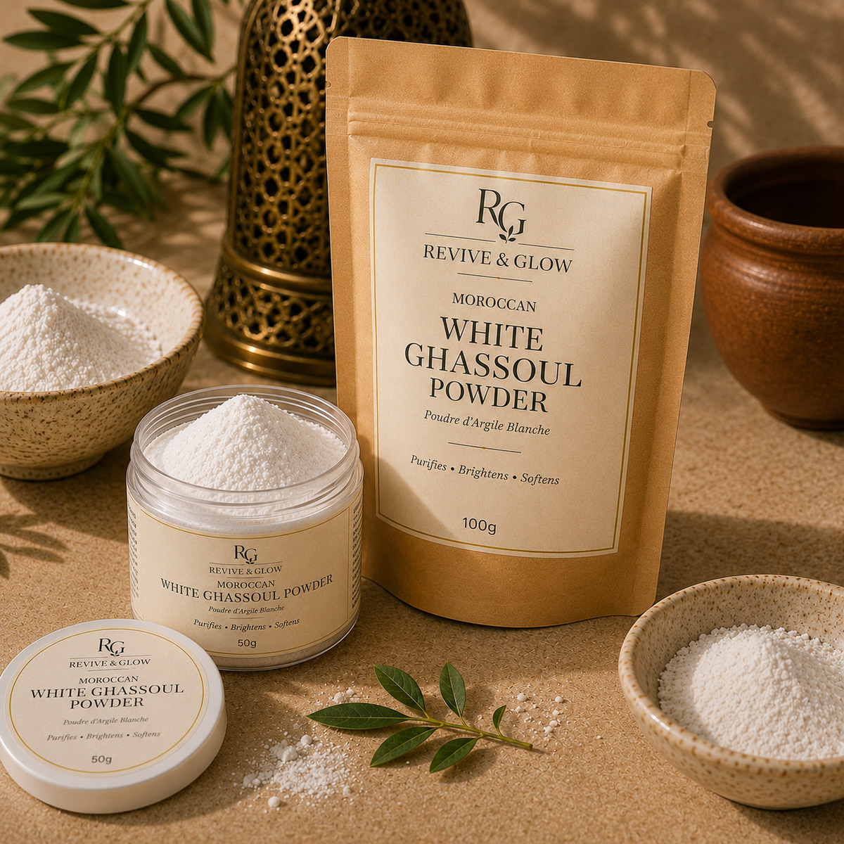 Revive & Glow Moroccan White Ghassoul Powder shown in a kraft paper stand-up pouch, a clear jar with white powder, a small round tin lid, and bowls of the powder on a beige surface with decorative props.